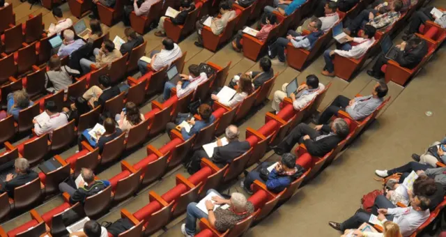 Conference audience seated in rows facing the stage
