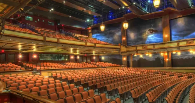 Large expo hall with tiered seating and stage lighting