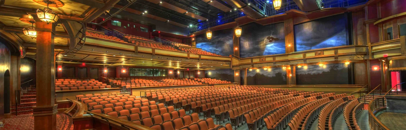 Large expo hall with tiered seating and stage lighting