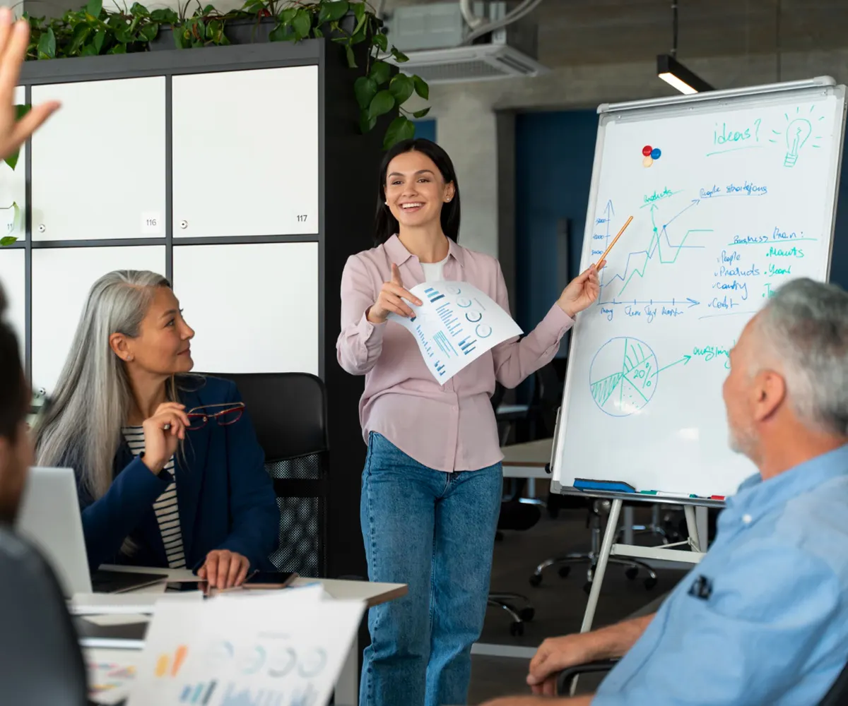 Facilitator presenting at a whiteboard to a seated group